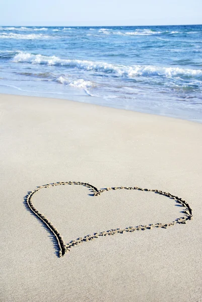 Contour du cœur sur sable contre vague — Photo