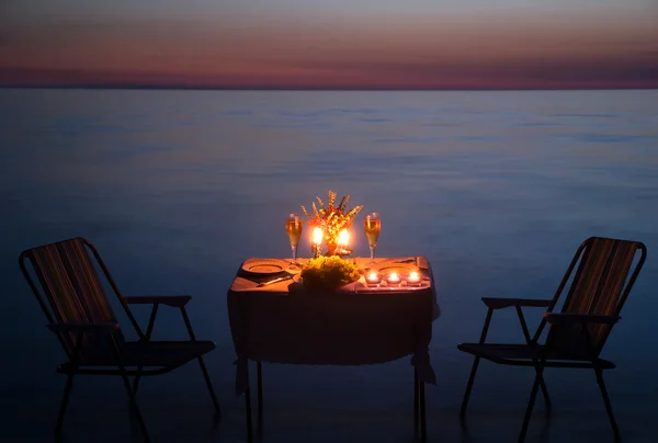 Cena romantica sulla spiaggia di mare con candele e vino — Foto Stock