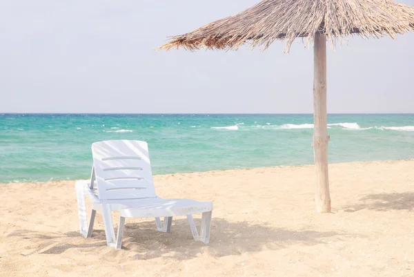 Salon plaży piaszczystej plaży pod strzechą parasolka — Zdjęcie stockowe