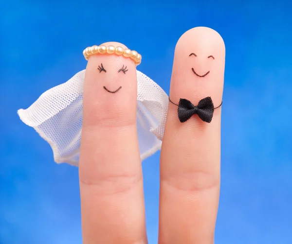 Just married concept - newlyweds painted at fingers against blu — Stock Photo, Image