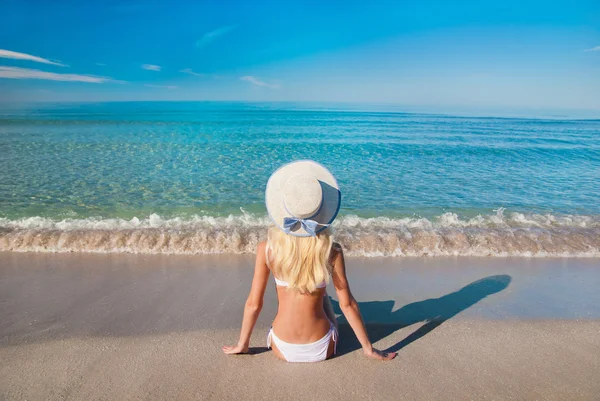 Niedliche blonde Frau im weißen Bikini am Sandstrand — Stockfoto