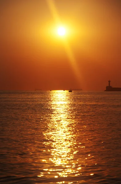 Ljusa vertikala solnedgången under havet ytbehandlar — Stockfoto