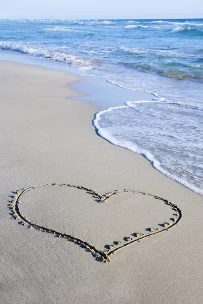 Obrys srdce na písku proti vlně — Stock fotografie