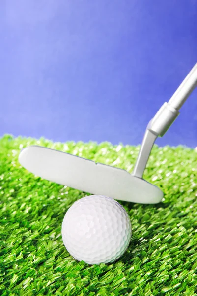 Pelota de golf y club en el césped campo verde contra el cielo azul — Foto de Stock