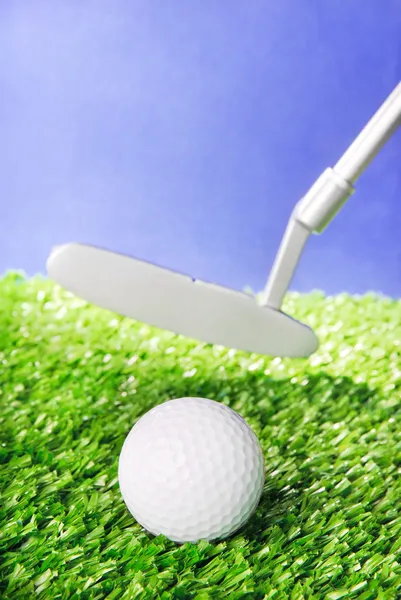 Bola de golfe e clube em grama campo verde contra o céu azul — Fotografia de Stock