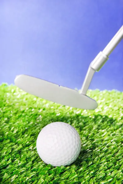 Golf ball and club on green field grass against blue sky — Stock Photo, Image