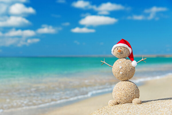 Sandy snowman in santa hat. Holiday concept for New Years and Ch