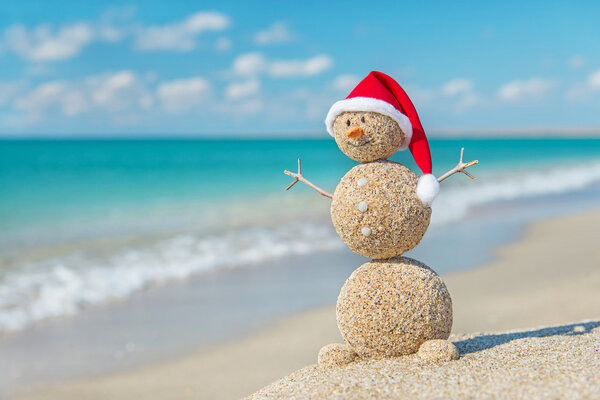 Sandy snowman in santa hat. Holiday concept for New Years and Ch