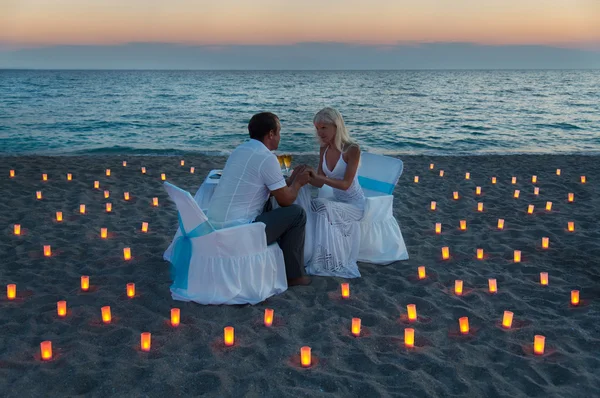 Amantes casal compartilhar um jantar romântico na praia do mar — Fotografia de Stock