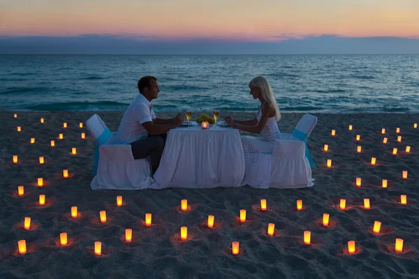 Pareja de amantes comparten una cena romántica en la playa del mar — Foto de Stock