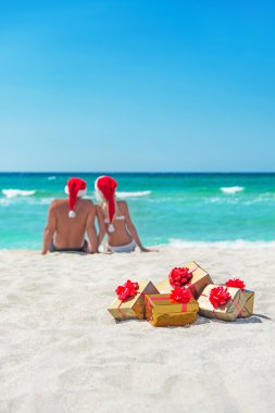 genç bir çift deniz plaj santa şapkalar