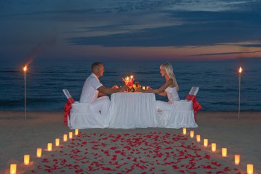 Genç çift romantik bir akşam yemeği mum ile paylaşmak.