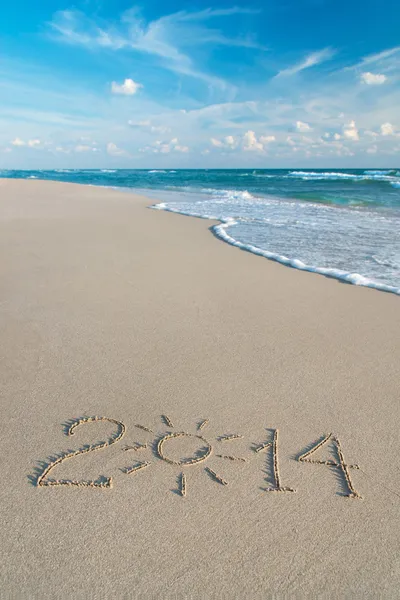 Inskriften 2014 på sea sand beach med solen strålar — Stockfoto