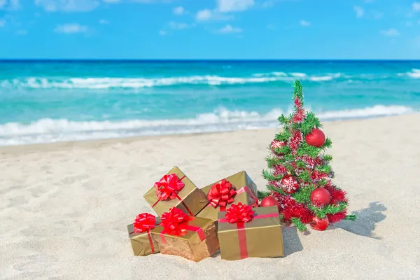 Christmas tree and golden gift with big red bow — Stock Photo, Image