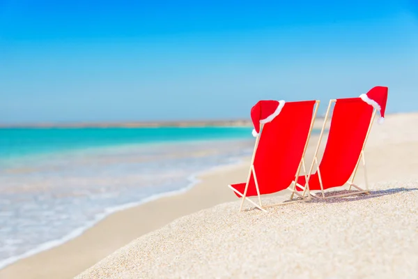 Sombrero de Santa en chaise longues en la playa de arena blanca —  Fotos de Stock