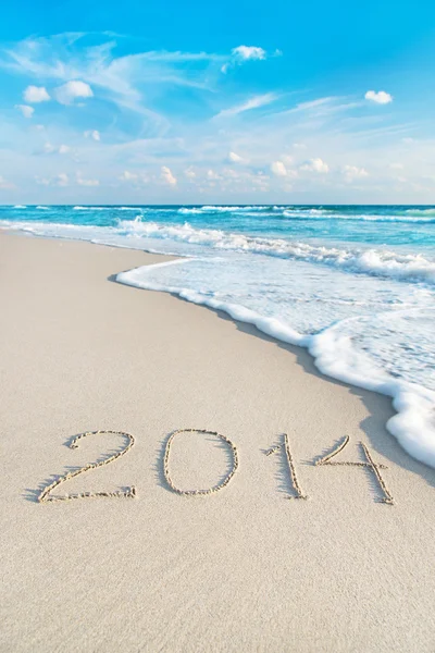 Inscrição 2014 na praia de areia do mar com os raios de sol — Fotografia de Stock