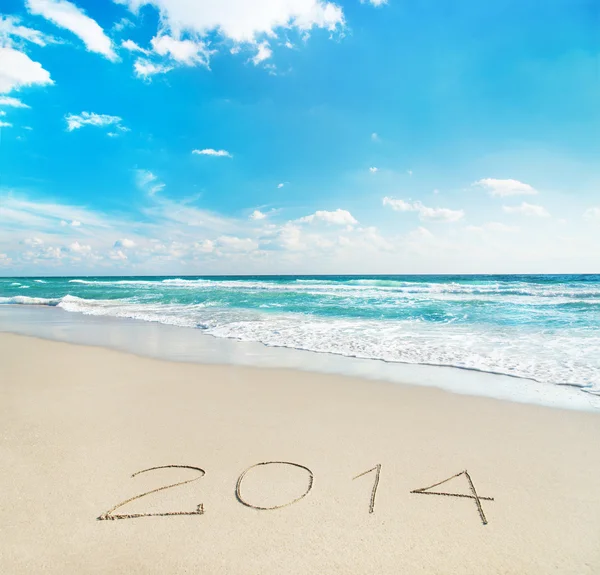 Inscripción 2014 en la playa de arena de mar con los rayos del sol —  Fotos de Stock