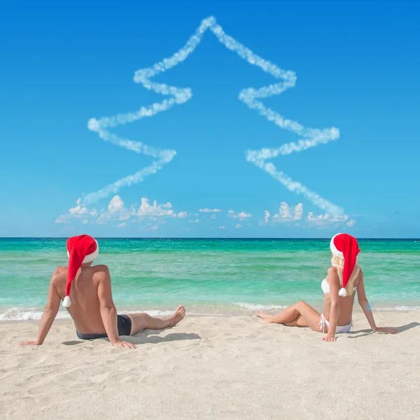 Couple amoureux en chapeaux de Père Noël à la plage de sable tropical - Noël — Photo