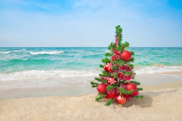 Árvore de Natal na praia do mar. Conceito de férias de Natal . Fotos De Bancos De Imagens