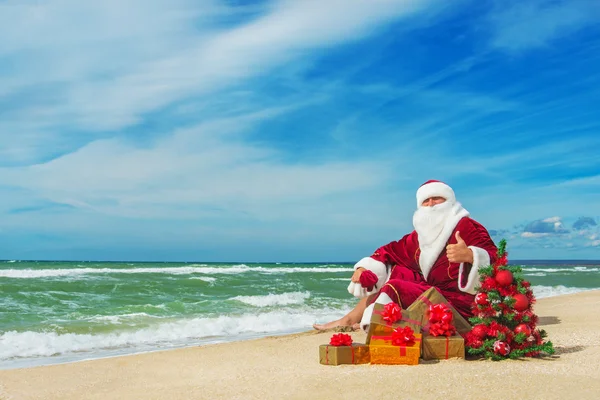 Santa Claus at sea beach with many gifts Stock Photo