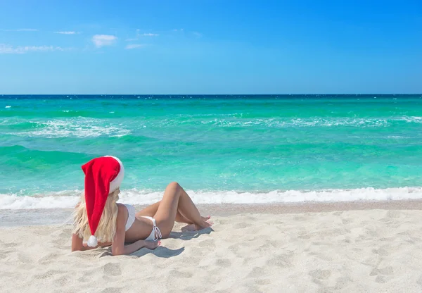 Mooie blonde vrouw in bikini en rode kerstmuts — Stockfoto
