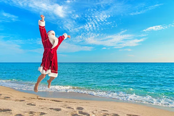 Santa Claus flying against sea beach - Christmas concept — Stock Photo, Image