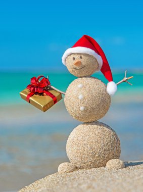 Smiley kumlu kardan adam Beach deki altın Hediyelik Noel şapka.