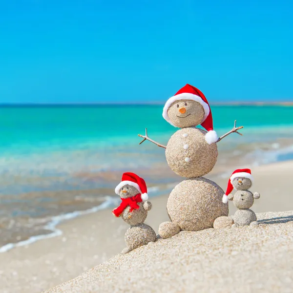 sea Beach santa şapka içinde Snowmans aile.