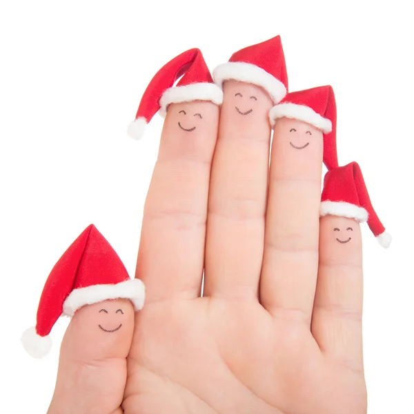 Las caras de los dedos en los sombreros de Santa. Feliz familia celebrando concepto fo — Foto de Stock