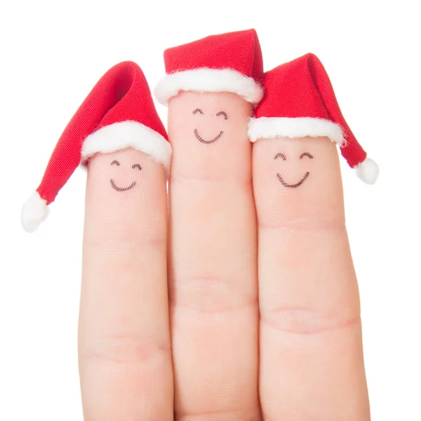 Las caras de los dedos en los sombreros de Santa. Feliz familia celebrando concepto fo — Foto de Stock