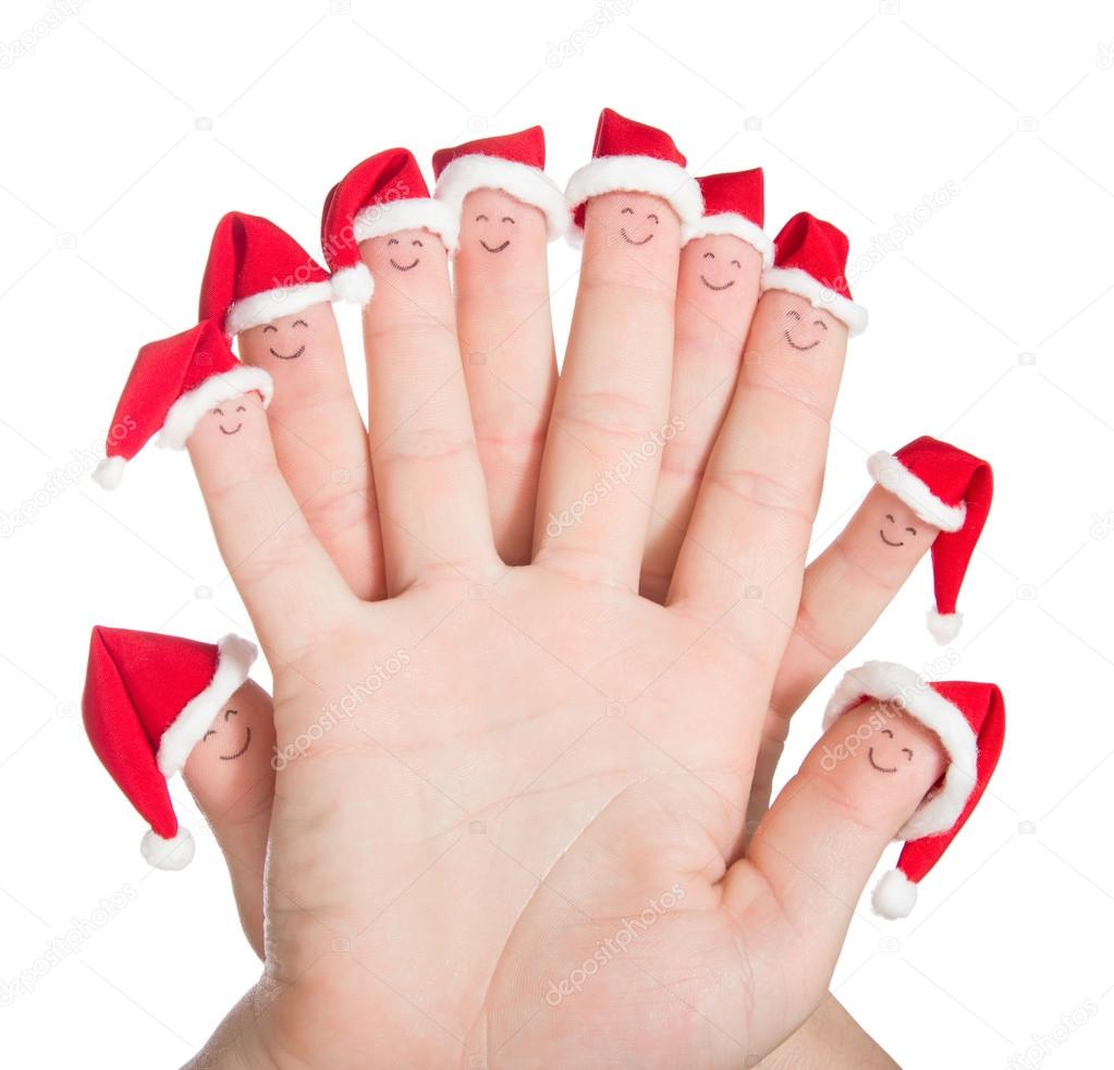 Fingers faces in Santa hats. Happy family celebrating concept fo