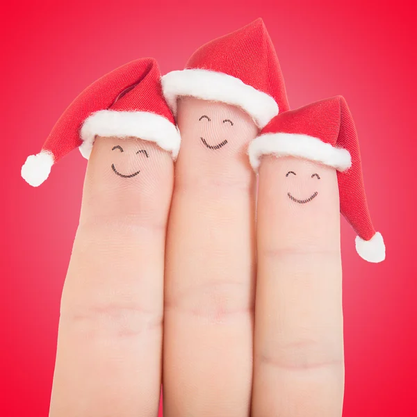 Fingergesichter in Weihnachtsmannhüten — Stockfoto