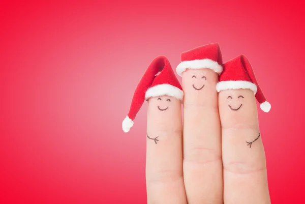 Fingergesichter in Weihnachtsmannhüten — Stockfoto