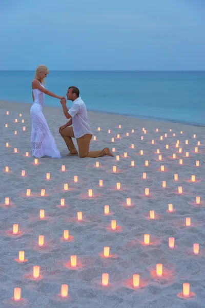 Proposal at sea beach in candles against sunset — Stock Photo, Image