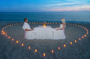 Plaj romantik bir akşam yemeği mum kalp ile çifte
