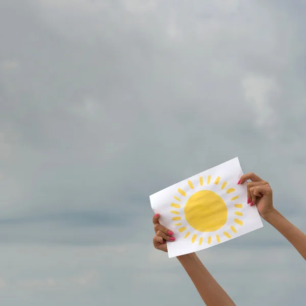 Hoja de papel con imagen de sol contra cielo nublado — Foto de Stock