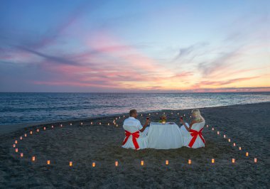 Aşık çift kalp mumlar ile romantik bir akşam yemeği var