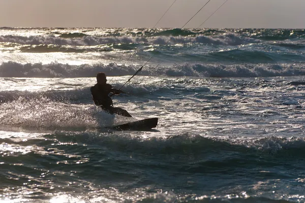 カイト サーフィン。kitesurfer 日没で波に乗る — ストック写真