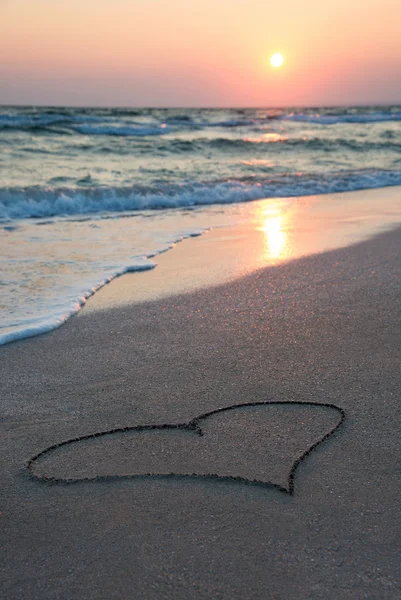 Hart overzicht op strand zand tegen de zee en de zonsondergang — Stockfoto