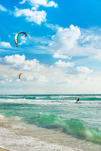 Kitesurfen. kitesurfers rijdt de golven tegen hemel. — Stockfoto