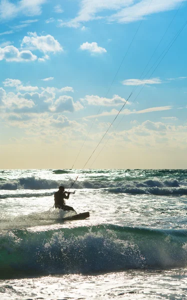 Kitesurfen. kitesurfer rijdt de golven bij zonsondergang — Stockfoto