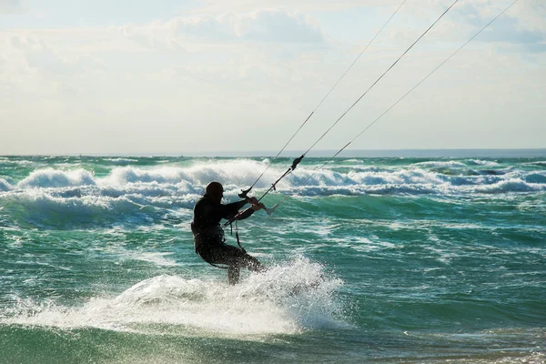 Kitesurfing. Kitesurfer rider bølgerne ved solnedgang - Stock-foto