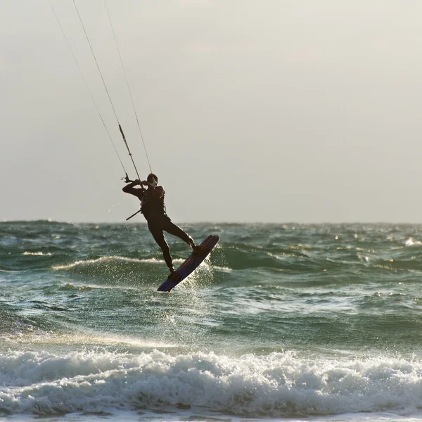 カイト サーフィン。kitesurfer 日没で波に乗る — ストック写真