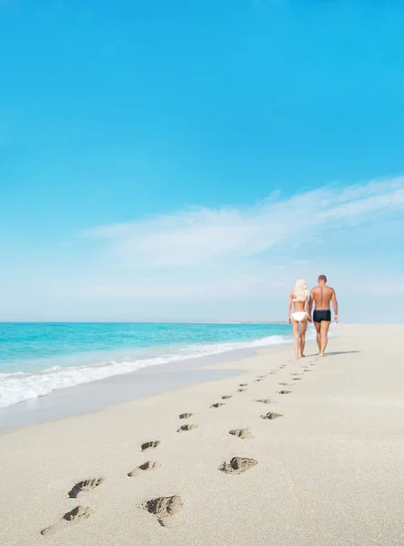 Couple amoureux marchant avec des empreintes de pas à la mer plage de sable fin — Photo