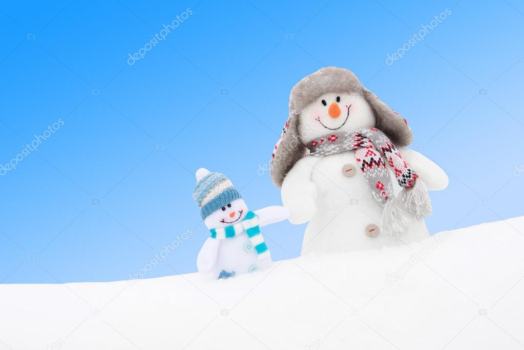 Happy winter snowmen family or friends against blue sky