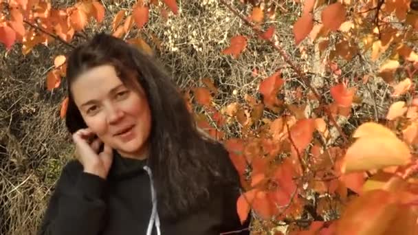 Γυναίκα χαμογελά ανάμεσα στα φθινοπωρινά δέντρα. — Αρχείο Βίντεο