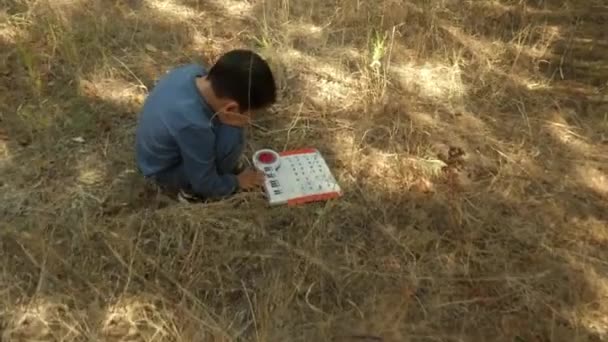 Seorang anak kecil yang berjongkok di tanah kering. — Stok Video