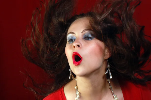 Retrato sobre mujer sexy en rojo con el pelo volador — Foto de Stock