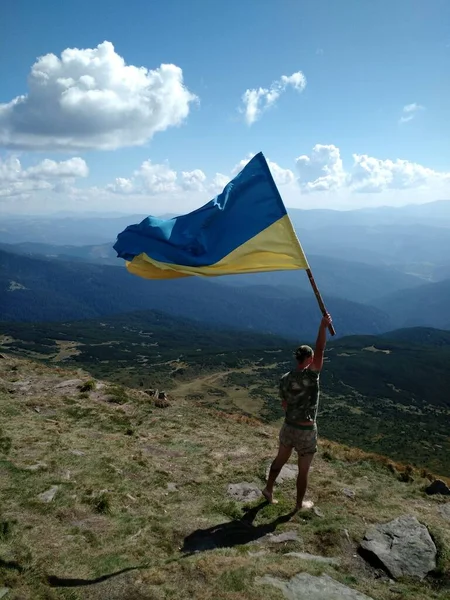 Людина Прапором України Вершині Гори — стокове фото