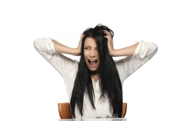 Eine frustrierte und wütende Frau schreit laut auf und zieht an ihren Haaren. Stockbild